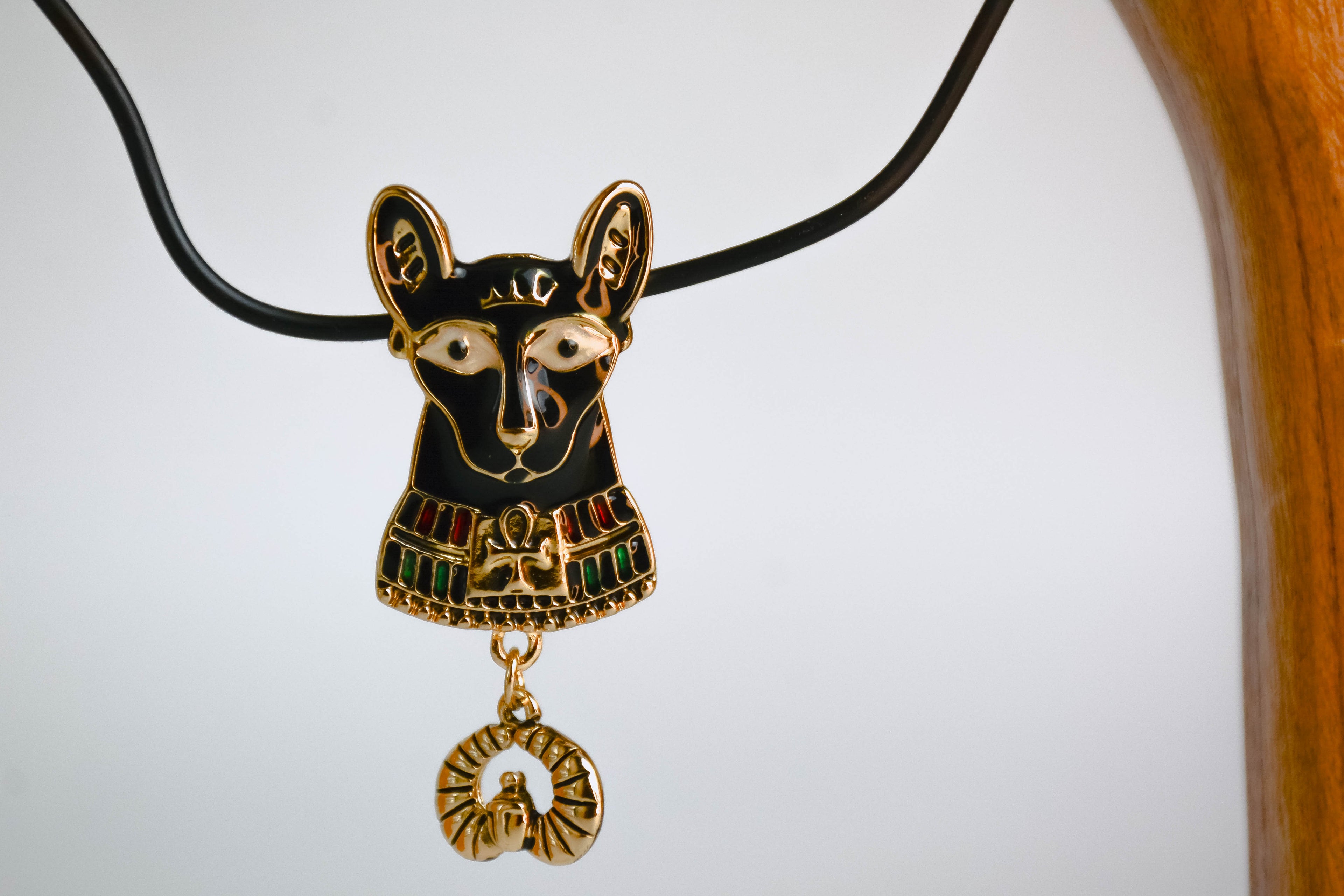 Bastet cat pendant hanging off of wooden arch