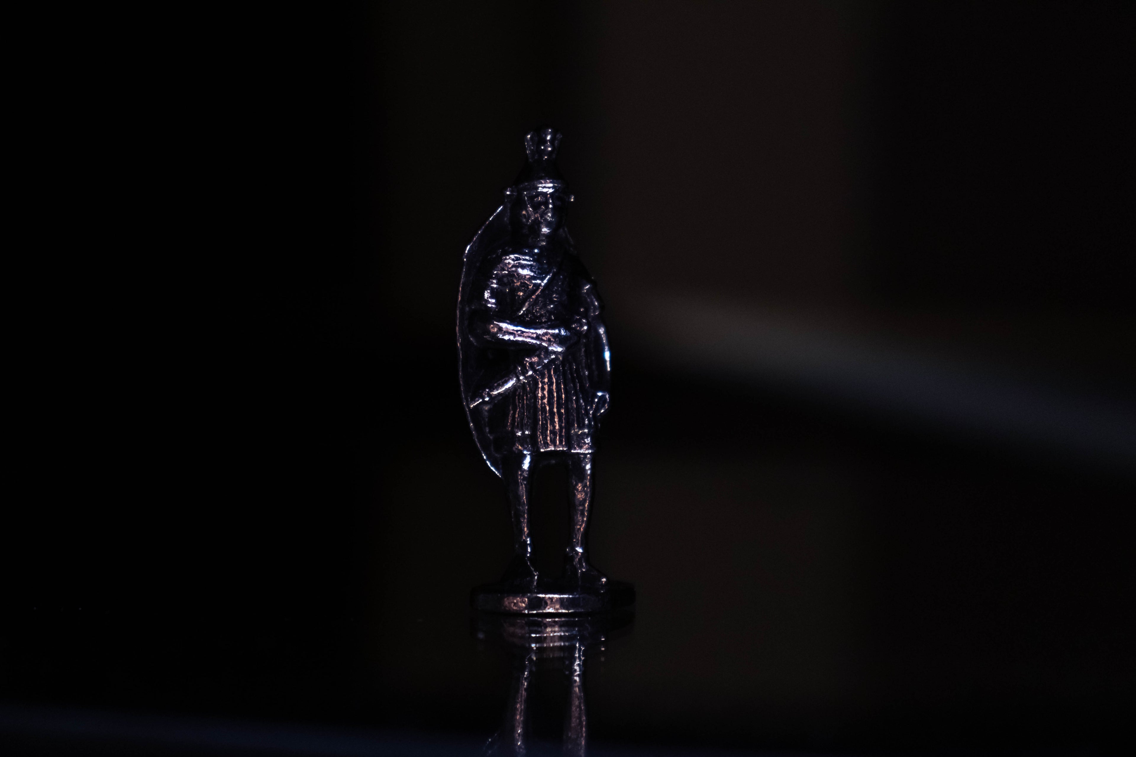 Legionary figurine with creative black and purple background. 