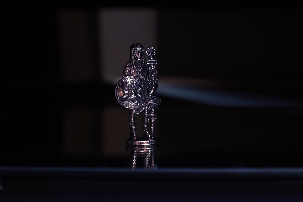 Signifer figurine with creative blue, purple, orange, and red lighting, as well as a reflection on the bottom. 