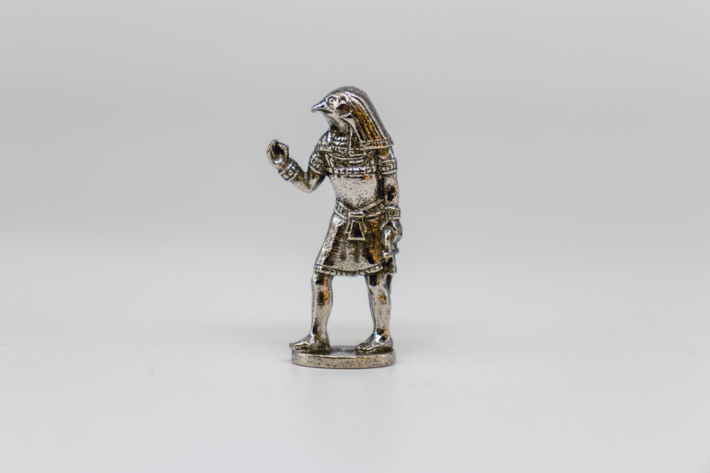 Horus figurine, silver with black detailing. On off-white background. 