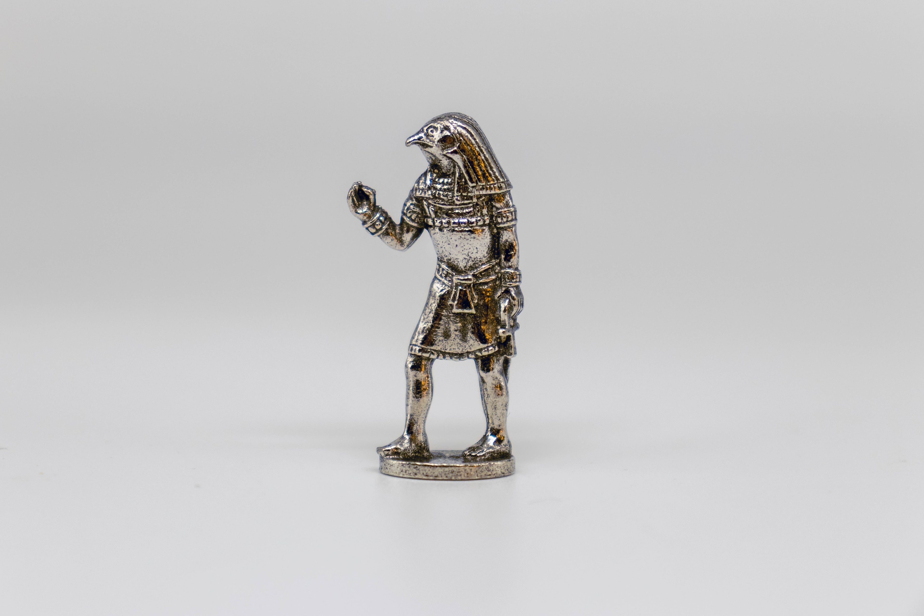 Horus figurine, silver with black detailing. On off-white background. 