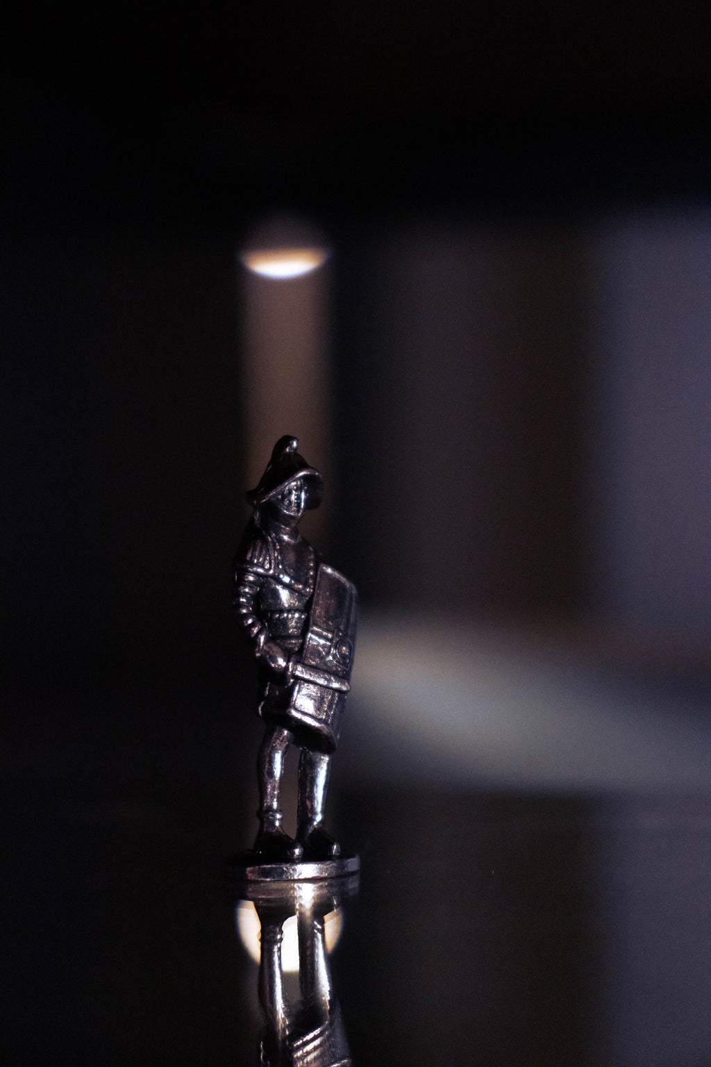 Gladiator figurine on purple and black background, with lights shining around.