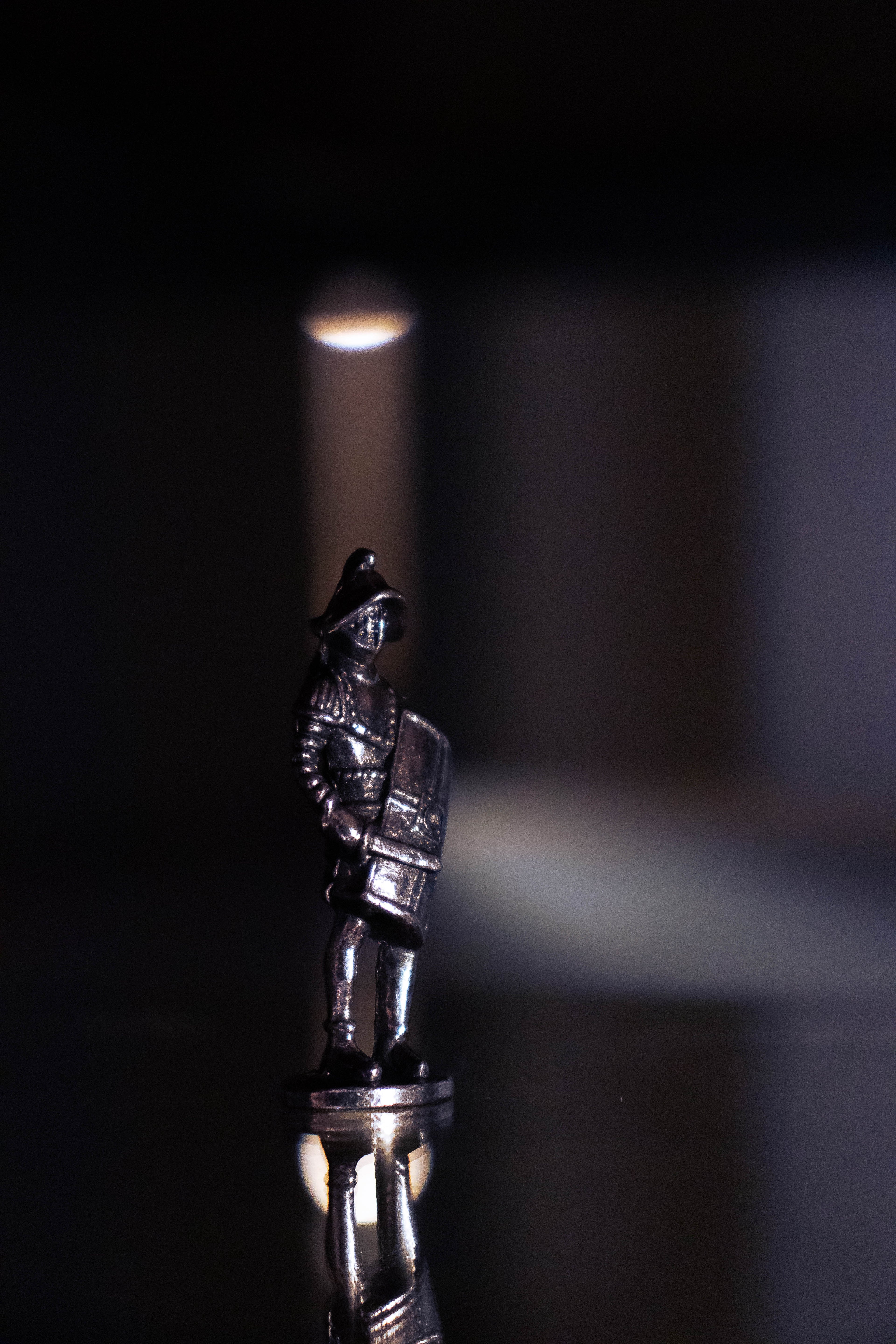 Gladiator figurine on purple and black background, with lights shining around.