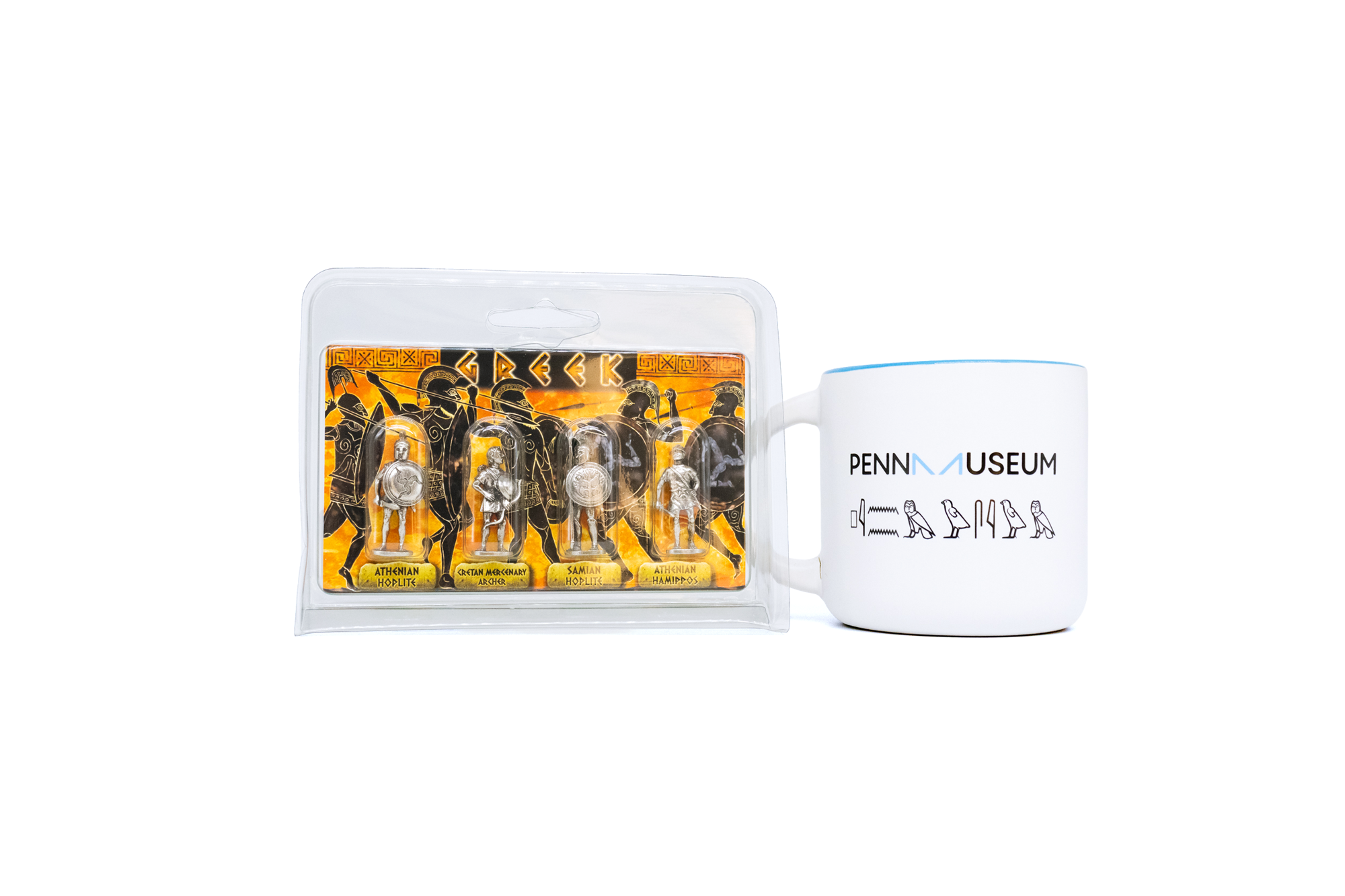 Penn Museum mug to the right of four silver Greek warrior figurines in plastic container. On white background. 