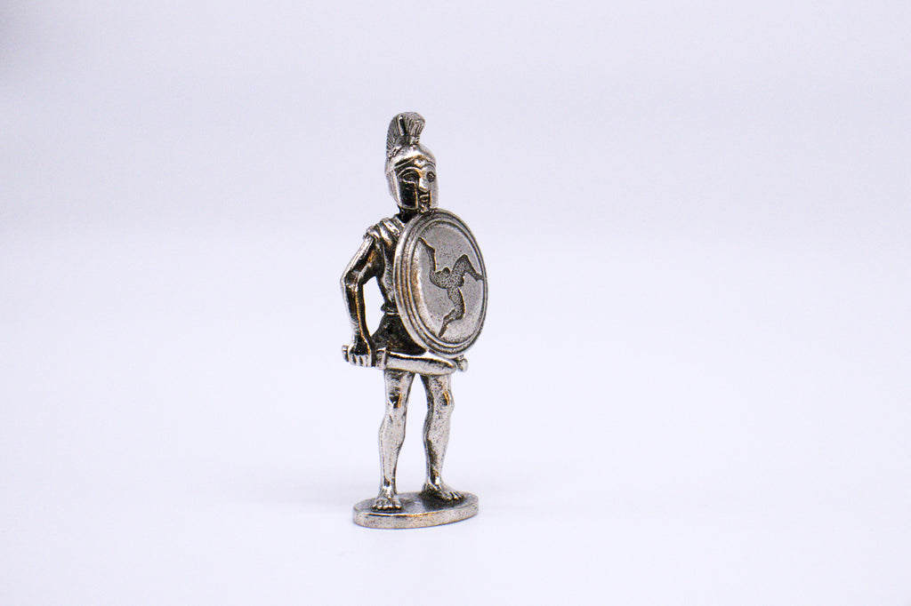 Silver Athenian Hoplite figurine holding sword and shield, on small pedestal. White background. 