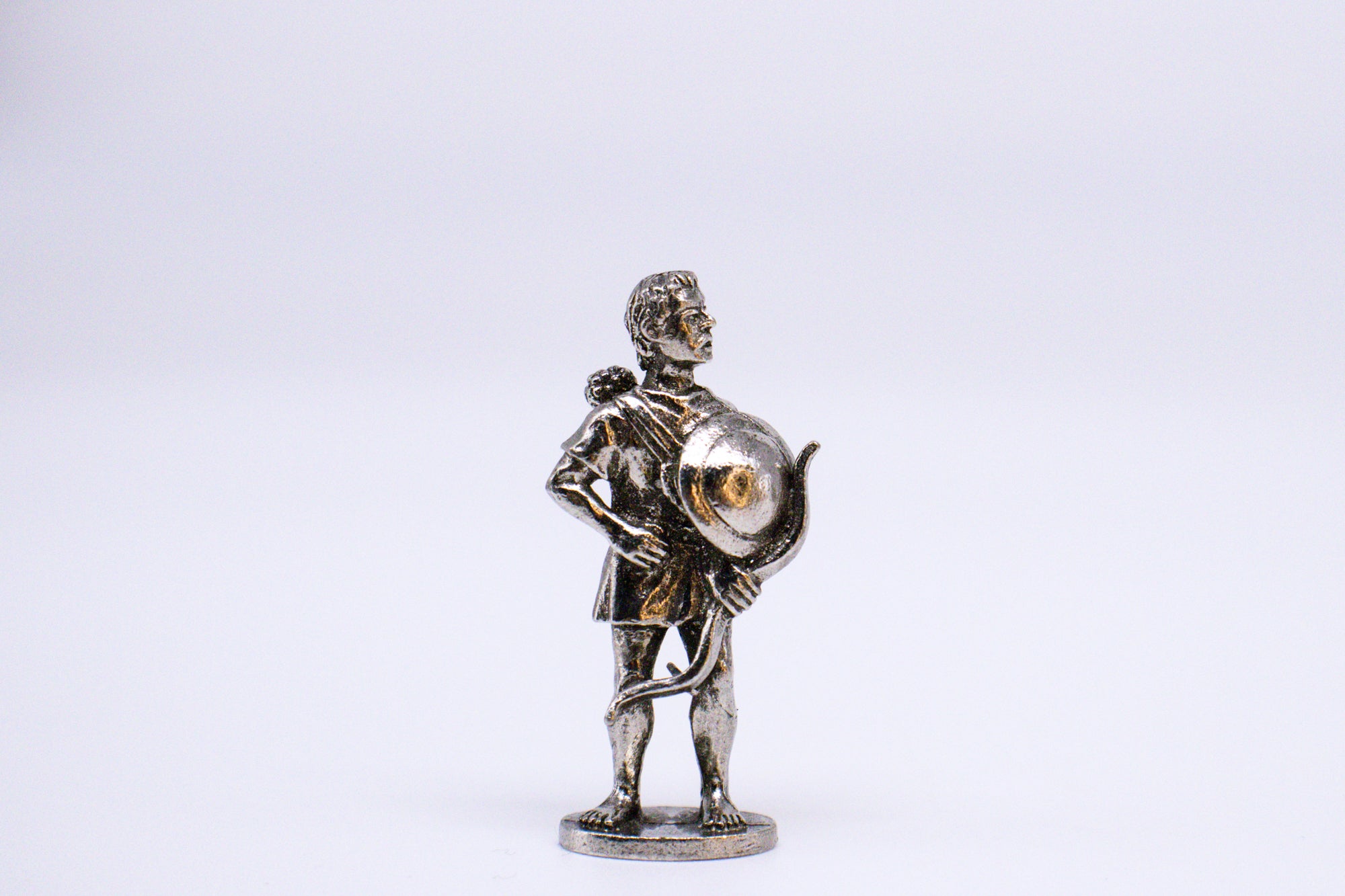Silver-colored Greek Cretan Mercenary Archer figurine holding crossbow in one hand and with shield.