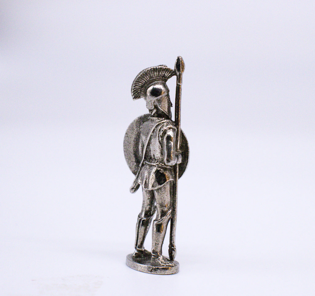 Silver-colored Samian Hoplite back view of figurine. Samian Hoplite wearing helmet, holding spear, carrying shield. On white background. 