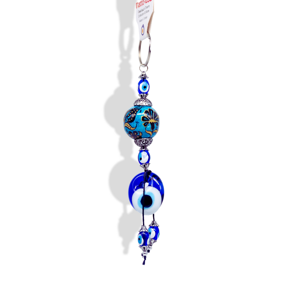 Evil Eye Nazar charm keychain with vibrant blue glass beads, silver beads, and  a sphere patterned blue bead with flower drawings. 