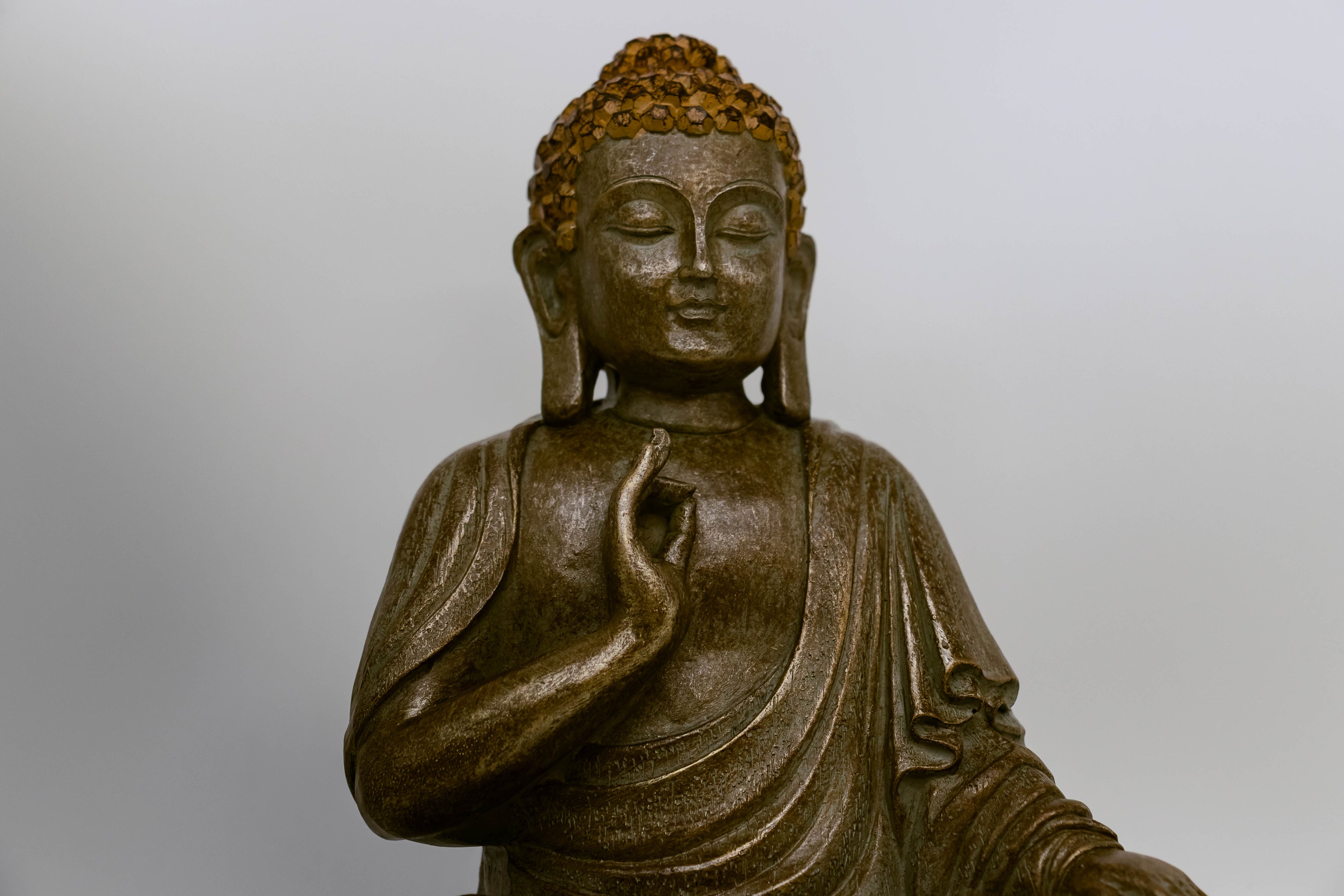 Close-up of Buddha Siddhartha's head and torso on white background. 