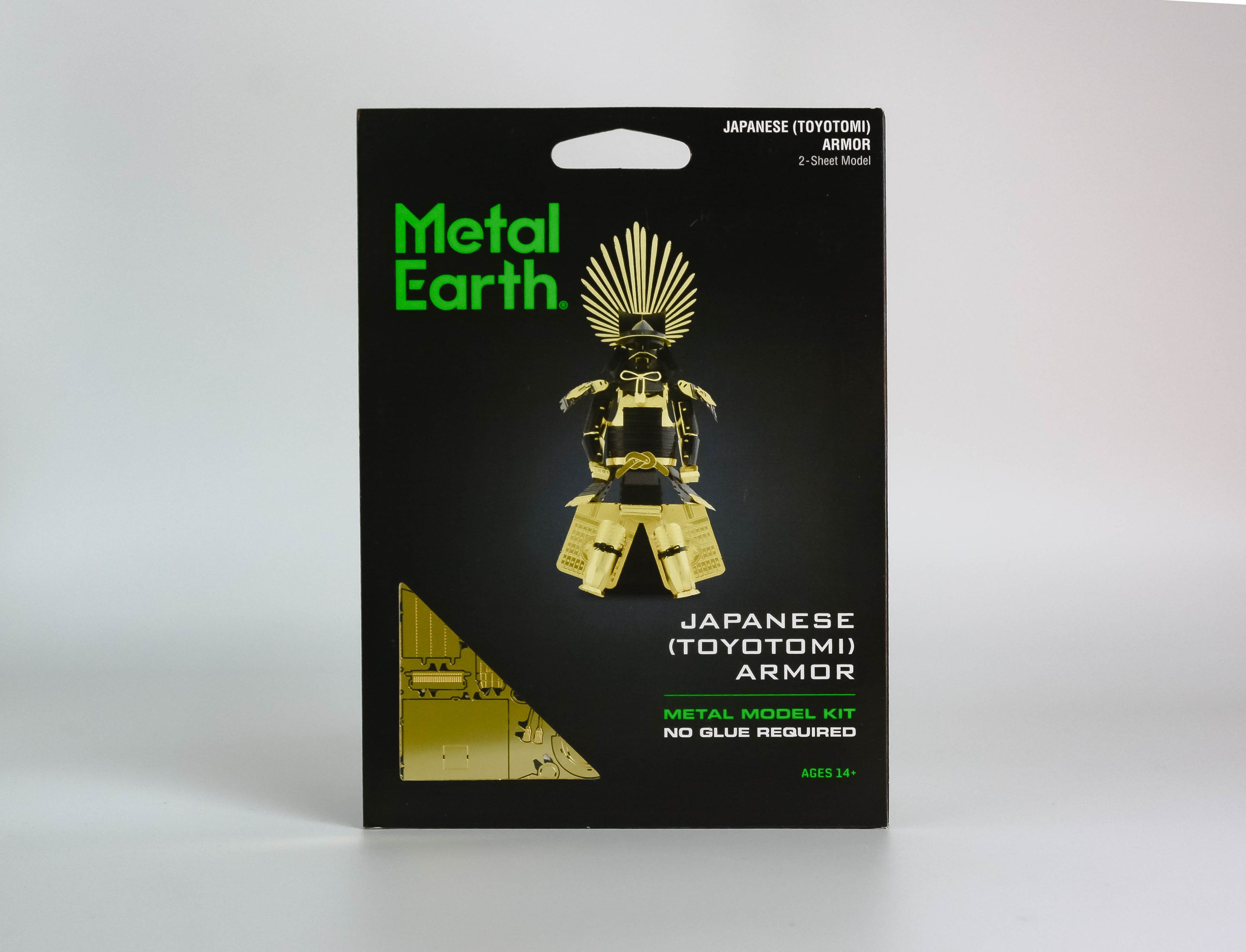 Black activity kit with green text "metal earth," gold and black Japanese Toyotomi Armor in center. On white background. 